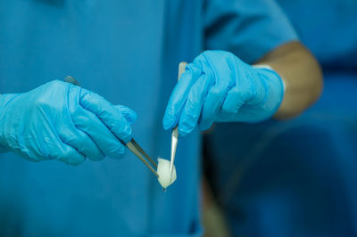 Close-up of human hand holding blue ring