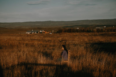 Man standing on field against sky