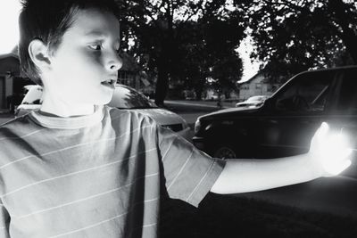 Boy standing against cars at yard