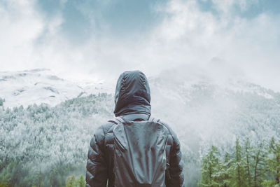 Rear view of man against sky during winter