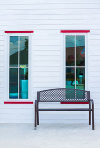 Empty bench on table against building