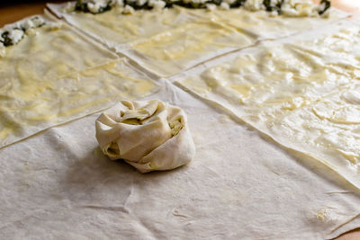 Sheets of dough for twisted patties with dock and white cheese on the table