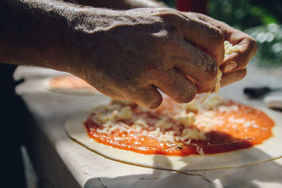 Close-up of hand holding pizza