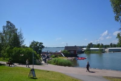 People in park by buildings against sky in city