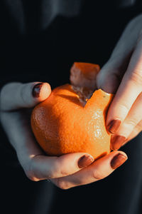 Close-up of hand holding orange fruit