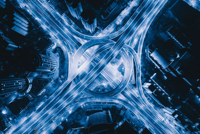 High angle view of illuminated street amidst buildings at night