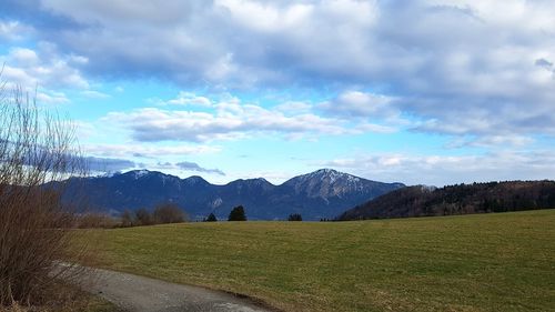 Scenic view of field and mountains against sky