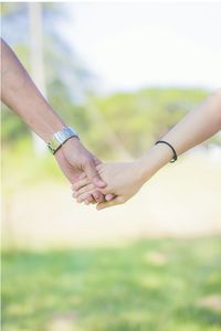 Midsection of couple holding hands outdoors