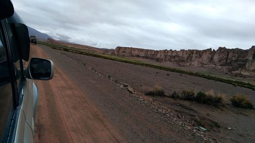 Car on road by land against sky