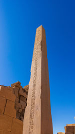 Low angle view of old ruins against clear blue sky