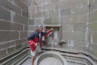 Portrait of smiling man standing at historic building