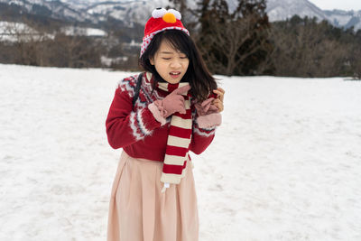 Woman making a face while standing on snow