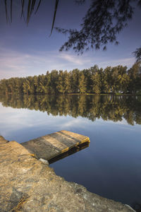 Scenic view of lake by trees against sky