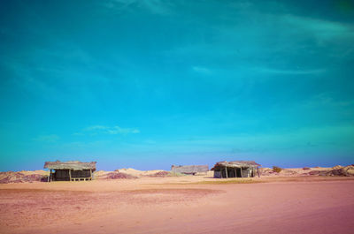 Built structure on beach against blue sky