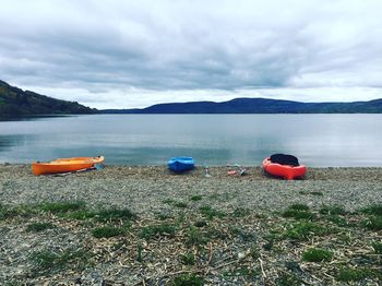 Boats moored on lake against sky