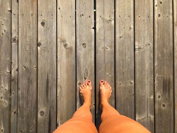 Low section of woman standing on wooden floor