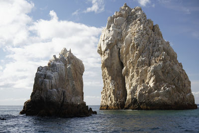 Scenic view of rock formation in sea against sky