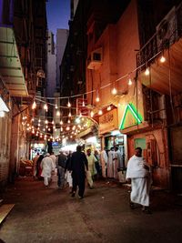 People walking on illuminated street market at night