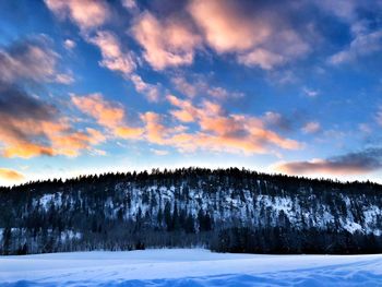 Scenic view of snow covered landscape against sky during sunset