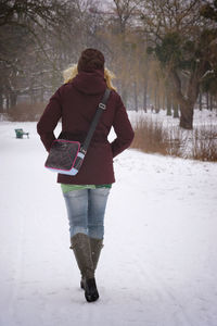 Woman walking on snowy field