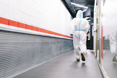 Healthcare man walking while wearing protective suit in hospital
