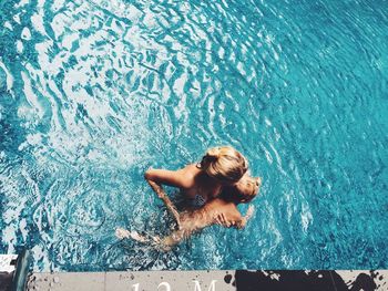 Portrait of woman swimming in pool with son