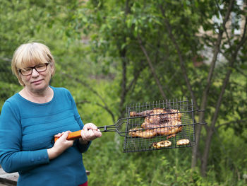 Young woman preparing food on barbecue grill