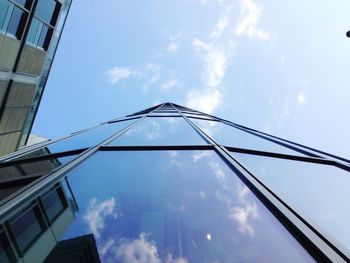 Low angle view of office building against cloudy sky