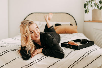 Woman lying down on bed at home