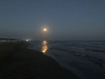Scenic view of sea against clear sky at night