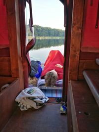 Man sleeping outside boat house by lake