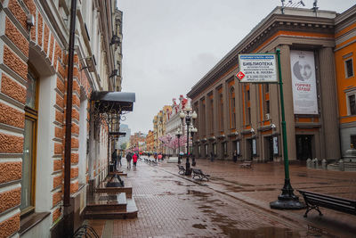 People on street amidst buildings in city