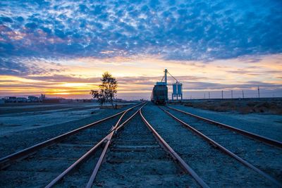 Vanishing point railroad tracks against sky