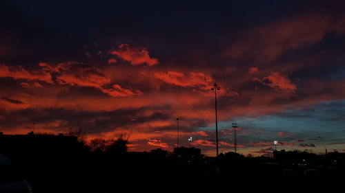 Low angle view of silhouette trees against dramatic sky