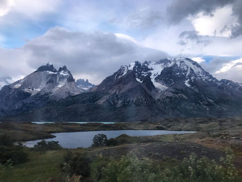 Scenic view of mountains and lake against cloudy sky