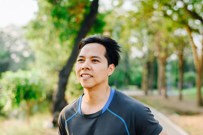 Portrait of smiling man standing against trees