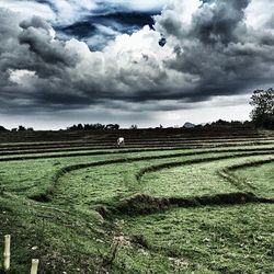 Scenic view of field against cloudy sky