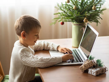 Boy using laptop at home