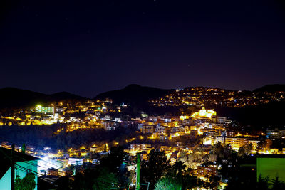 Illuminated cityscape against sky at night