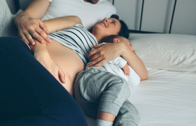 Family sleeping on bed at home