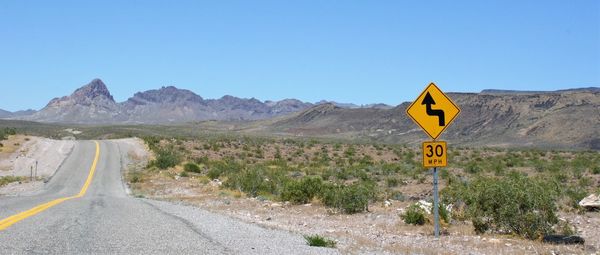 Road amidst mountains against clear sky