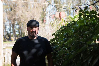 Young man against plants and trees