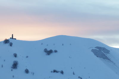 Scenic view of snow covered mountains against sky during sunset