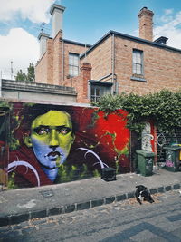 Graffiti on building wall by street in city
