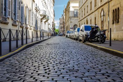 Cobblestone street amidst buildings in city