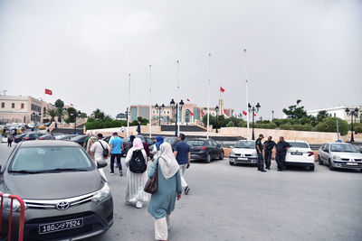 People on road against sky in city