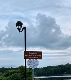 Information sign against sky