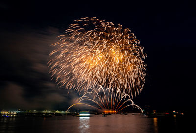 Firework display over river at night