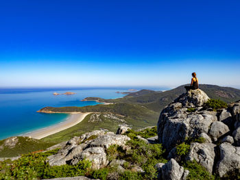 Man looking at sea against rocks