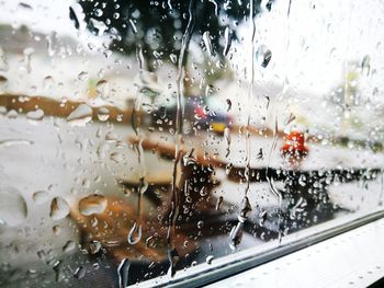 Close-up of wet car window during rainy season